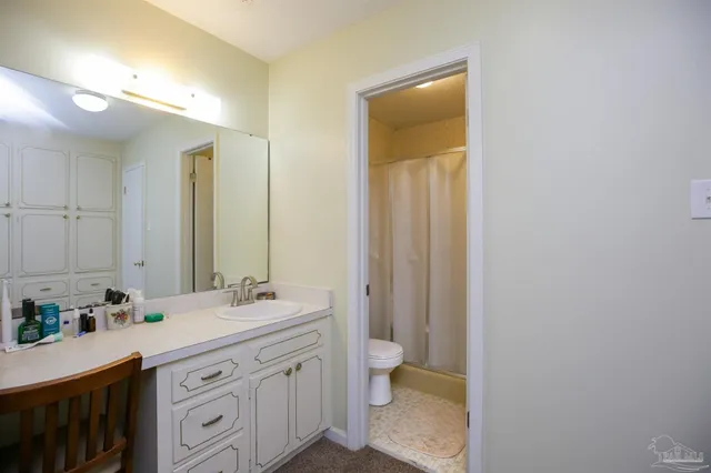 a bathroom with a double vanity sink toilet and a mirror
