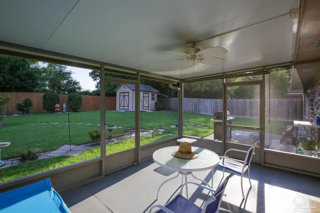 a view of a patio with a dining table and chairs with garden view