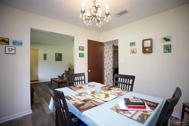a view of a dining room with furniture a chandelier and wooden floor
