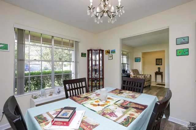 a view of a dining room with furniture a rug and wooden floor