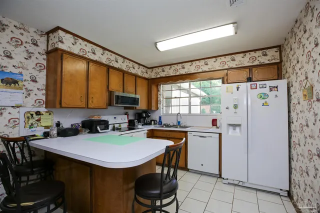 a kitchen with stainless steel appliances a table chairs and a refrigerator