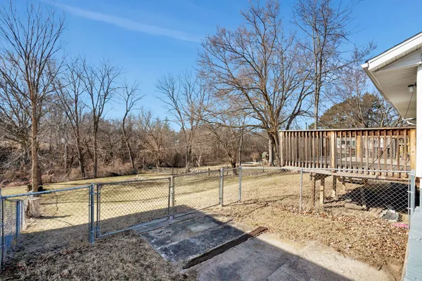 a view of a yard with wooden fence