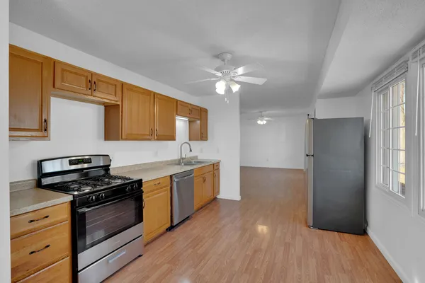 a kitchen with granite countertop a stove cabinets and wooden floor