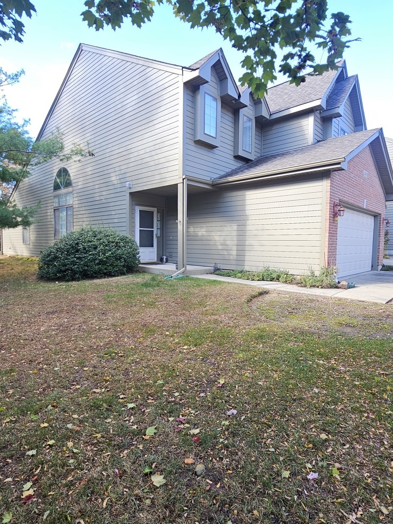 2013 Jeffrey Lane, Unit 2013 Elgin, IL 60123 - Photo 2 of 9 a view of a house with a yard and garage