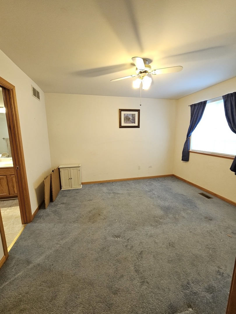 2013 Jeffrey Lane, Unit 2013 Elgin, IL 60123 - Photo 22 of 27 an empty room with a chandelier fan and windows