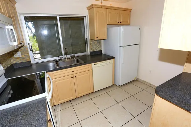 a view with a sink and dishwasher next to a window