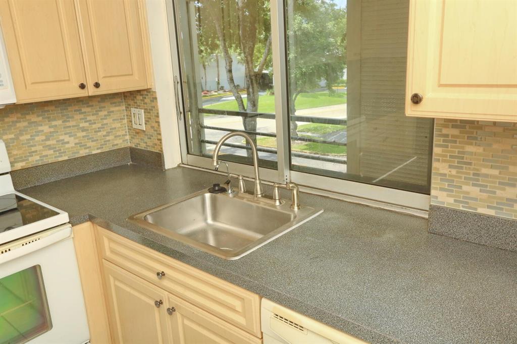 9151 Lime Bay Boulevard, Unit 310 Tamarac, FL 33321 - Photo 15 of 30 a view with a sink and dishwasher next to a window