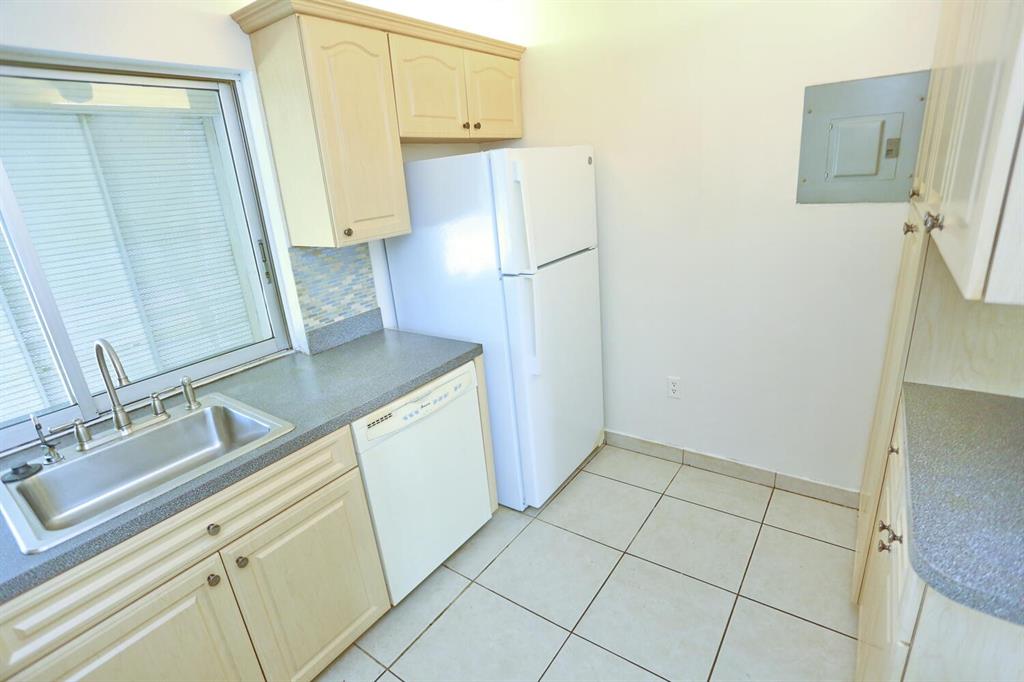 9151 Lime Bay Boulevard, Unit 310 Tamarac, FL 33321 - Photo 17 of 30 a kitchen with a sink and a refrigerator