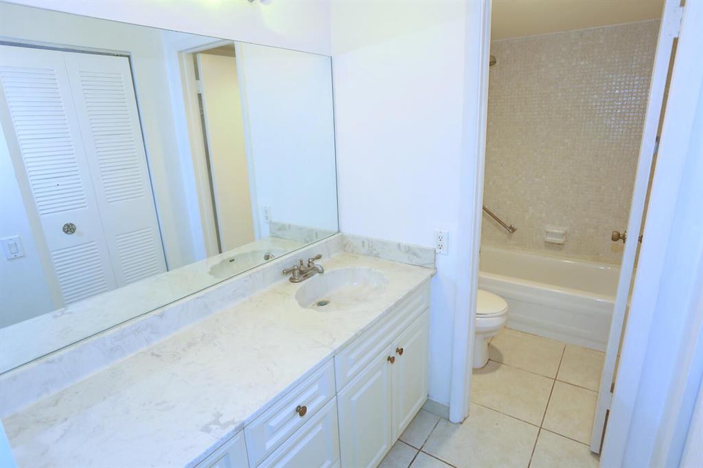 9151 Lime Bay Boulevard, Unit 310 Tamarac, FL 33321 - Photo 20 of 30 a bathroom with a sink a toilet and shower