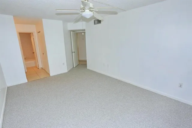 an empty room with a window and a fan