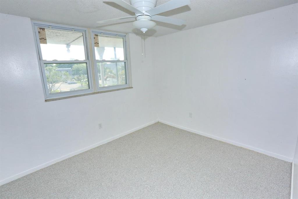 9151 Lime Bay Boulevard, Unit 310 Tamarac, FL 33321 - Photo 26 of 30 an empty room with a window and a fan