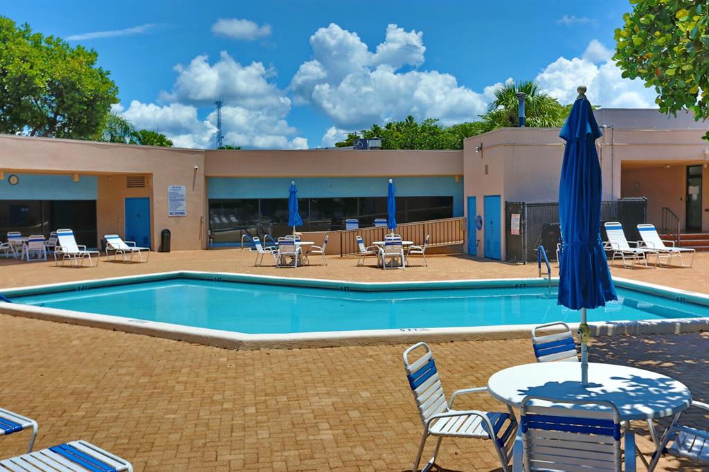 9151 Lime Bay Boulevard, Unit 310 Tamarac, FL 33321 - Photo 30 of 30 a view of a patio with swimming pool table and chairs