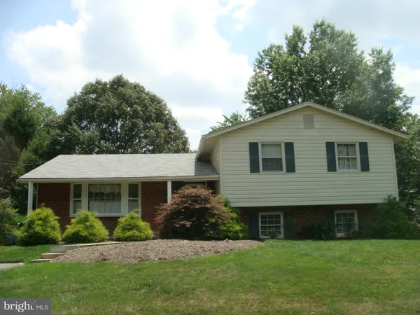 a front view of a house with a yard and trees