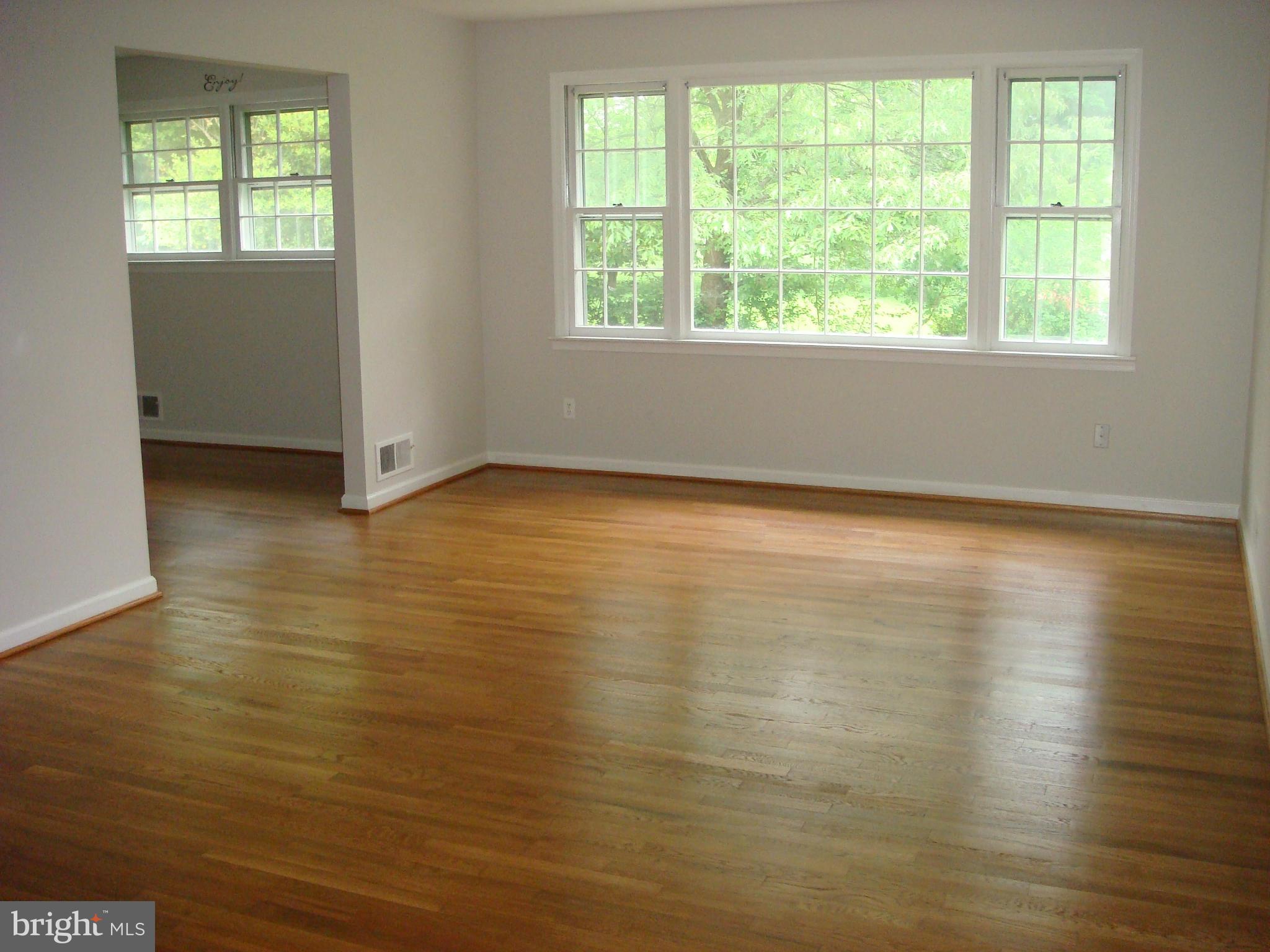 1 Tifton Court Potomac, MD 20854 - Photo 2 of 24 an empty room with wooden floor and windows