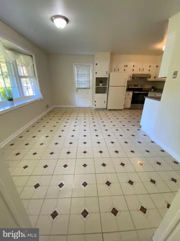 a kitchen with granite countertop a stove a sink and a refrigerator