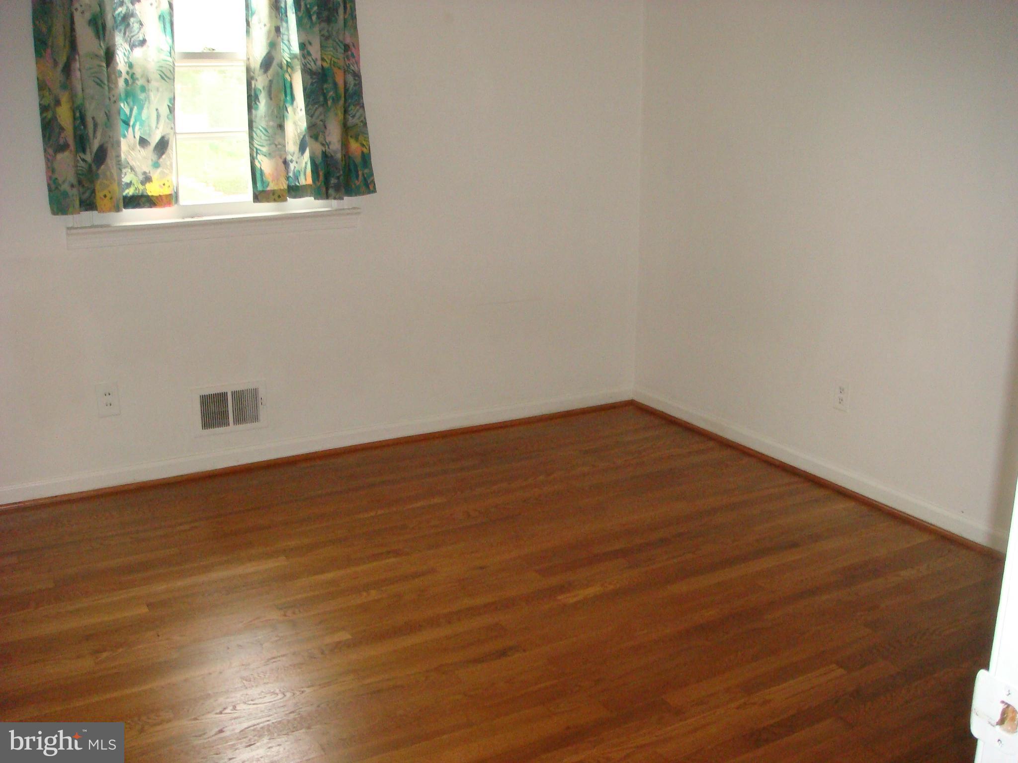 1 Tifton Court Potomac, MD 20854 - Photo 9 of 24 an empty room with wooden floor and windows