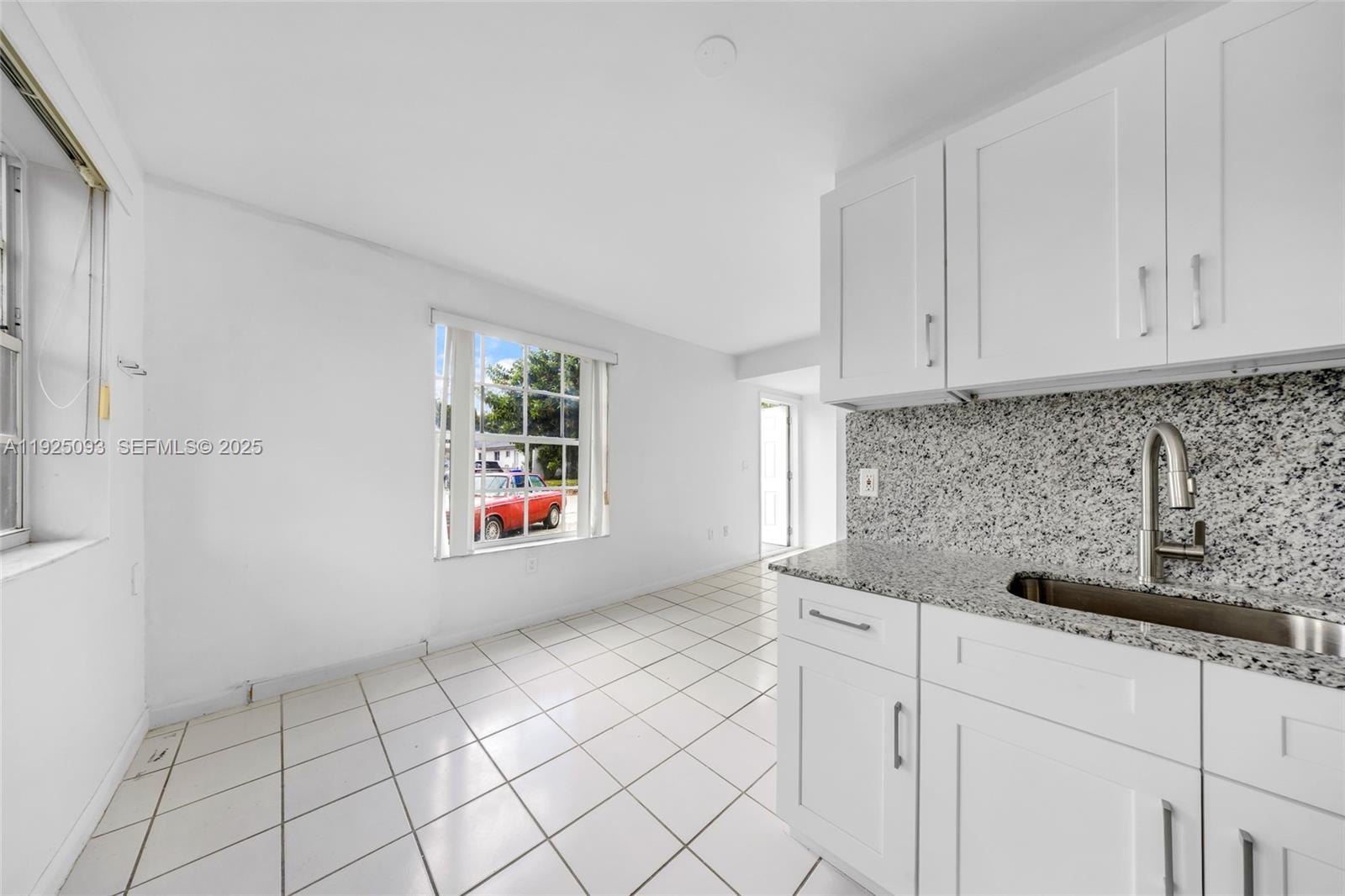 3453 Southwest 23rd Terrace, Unit 1 Miami, FL 33145 - Photo 6 of 22 a kitchen with white cabinets and window