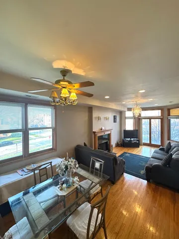a living room with furniture kitchen view and a large window