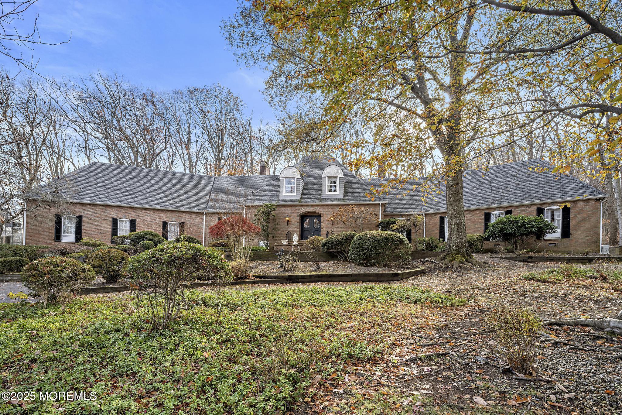 a front view of house with yard and trees around
