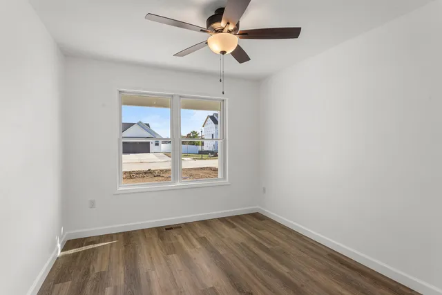 an empty room with a window and a fan