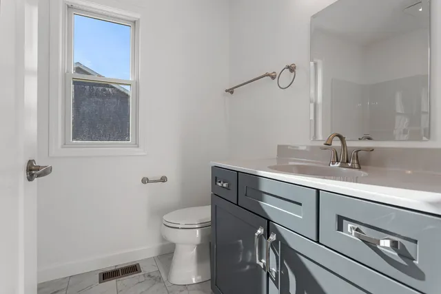 a bathroom with a sink a toilet and mirror