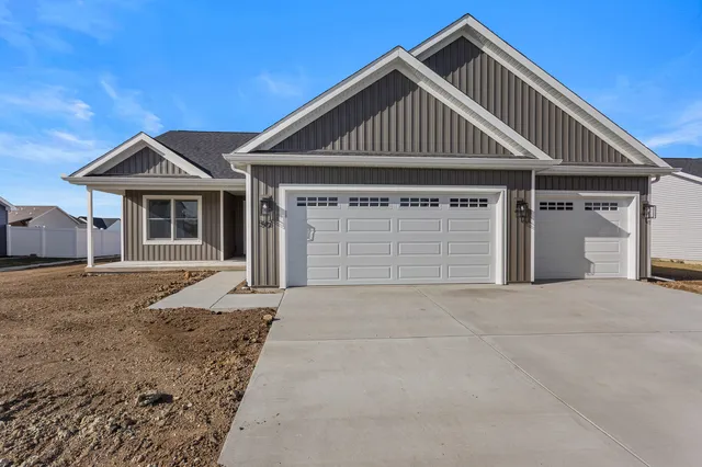 a front view of a house with a garden and yard