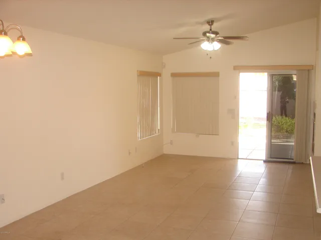an empty room with fan and entrance