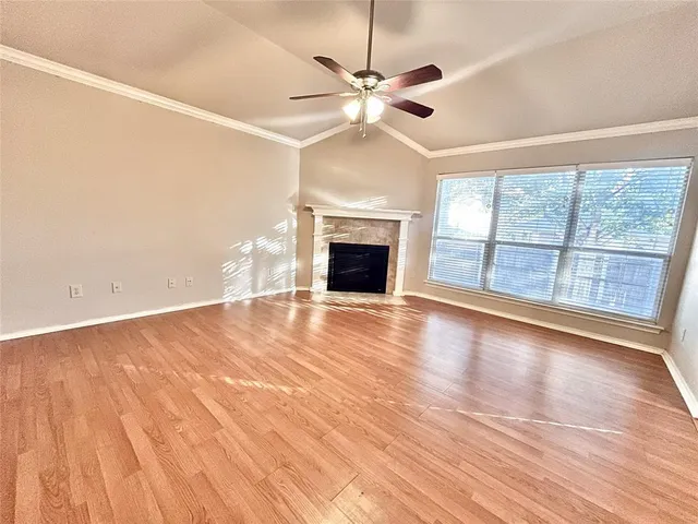 wooden floor fireplace and windows in an empty room