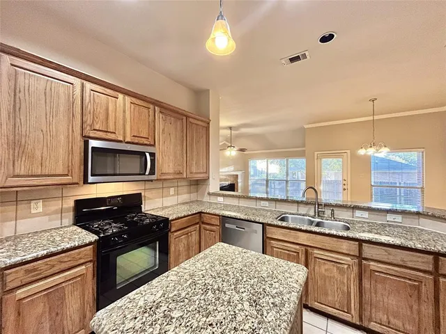 a kitchen with stainless steel appliances granite countertop a stove sink and cabinets