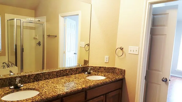 a bathroom with a granite countertop sink and a mirror