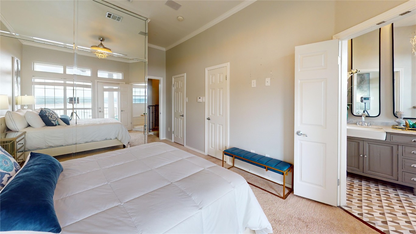 2918 Ranch Road 620, Unit 297 Austin, TX 78734 - Photo 10 of 37 Bedroom with a towering ceiling, light carpet, crown molding, connected bathroom, and french doors