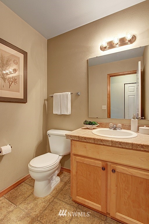 503 Ilwaco Avenue Northeast Renton, WA 98059 - Photo 14 of 17 a bathroom with a granite countertop toilet sink and a mirror