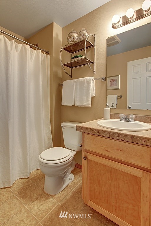 503 Ilwaco Avenue Northeast Renton, WA 98059 - Photo 16 of 17 a bathroom with a granite countertop toilet sink and mirror