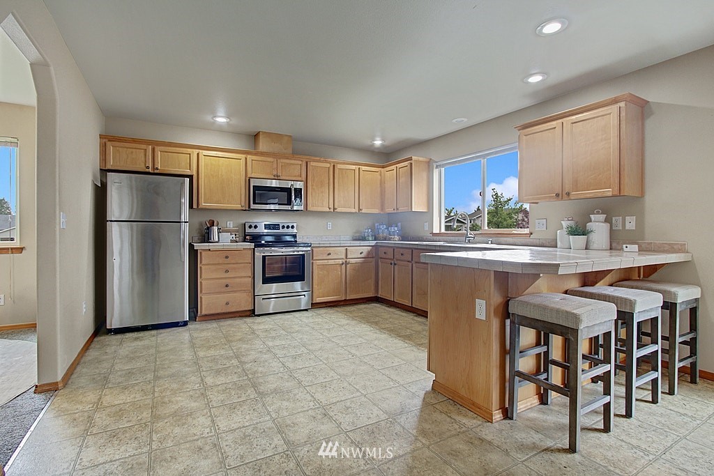 503 Ilwaco Avenue Northeast Renton, WA 98059 - Photo 6 of 17 a kitchen with granite countertop a sink stainless steel appliances and cabinets