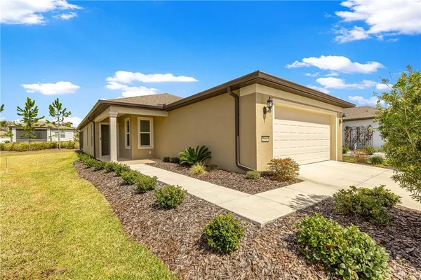 a front view of house with yard and trees in the background