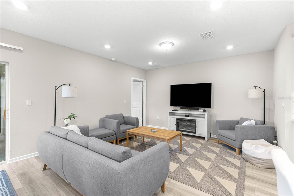 5466 Southwest 85th Ave Road Ocala, FL 34481 - Photo 11 of 36 a living room with furniture and a flat screen tv