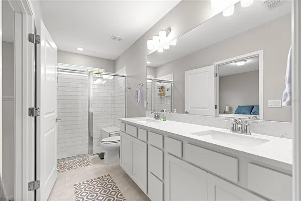 a spacious bathroom with a shower sink mirror and toilet