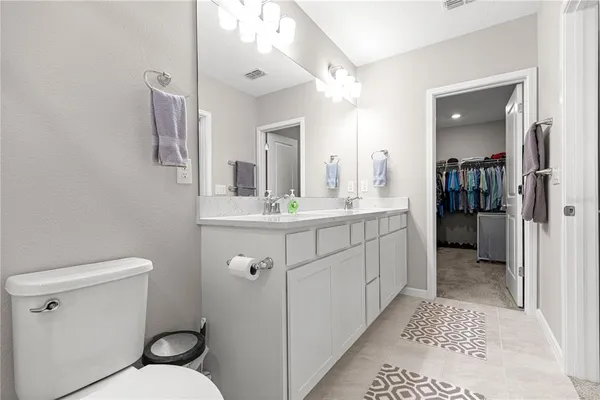 a bathroom with a sink a toilet a mirror and vanity