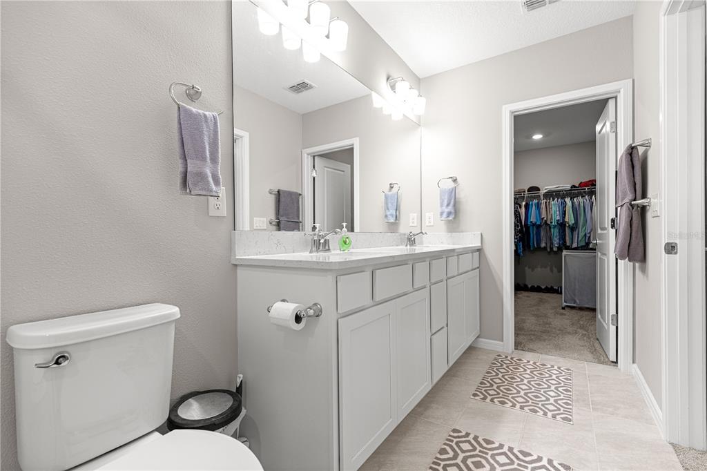 5466 Southwest 85th Ave Road Ocala, FL 34481 - Photo 19 of 36 a bathroom with a sink a toilet a mirror and vanity