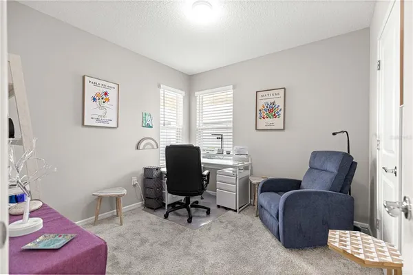 a living room with furniture a piano and a bookshelf