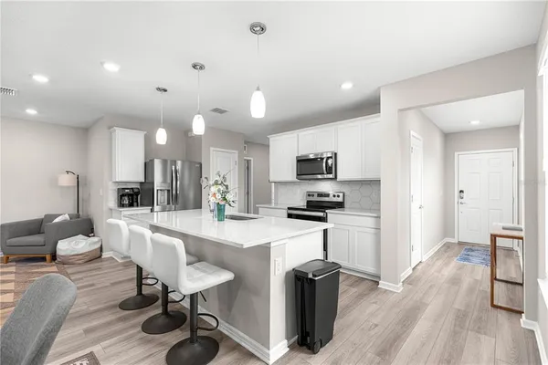 a large kitchen with stainless steel appliances lots of counter space and wooden floor