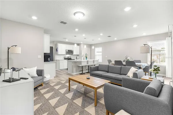 a living room with furniture and view of kitchen
