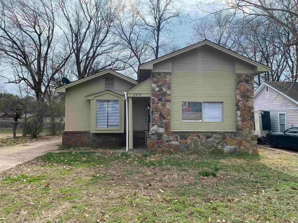 a front view of a house with a yard and trees