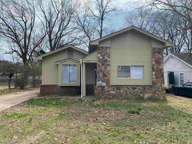a front view of a house with a yard and trees