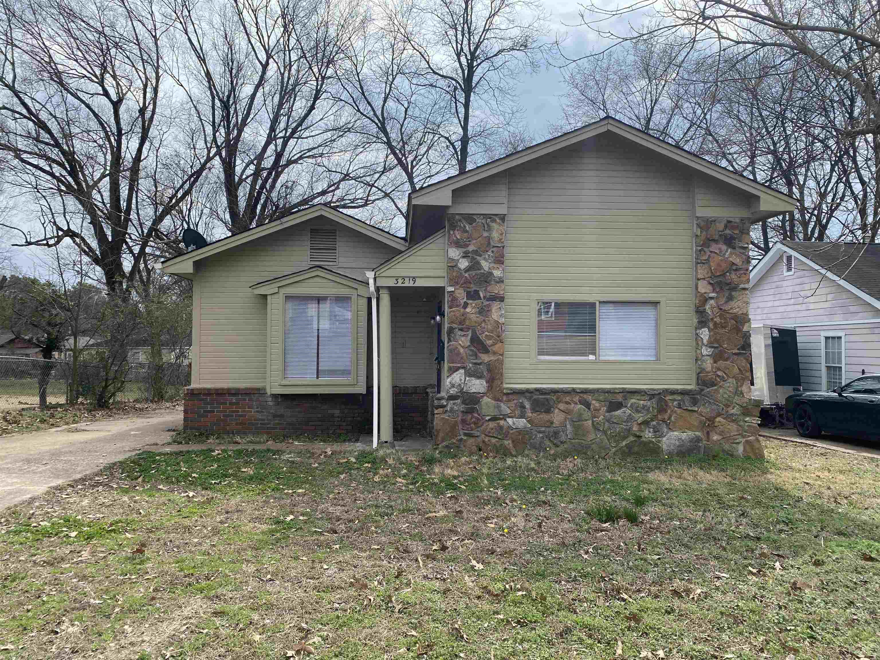 a front view of a house with a yard and trees