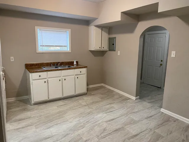 a kitchen with granite countertop a sink and cabinets