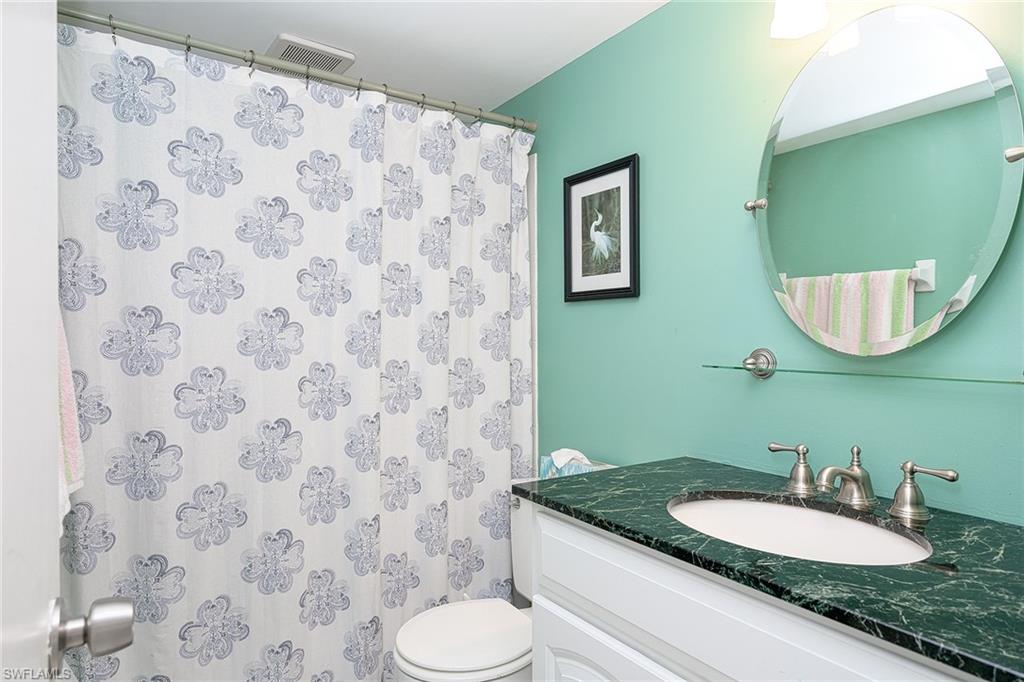 637 12th Avenue South, Unit 637 Naples, FL 34102 - Photo 13 of 35 a bathroom with a granite countertop sink and a mirror