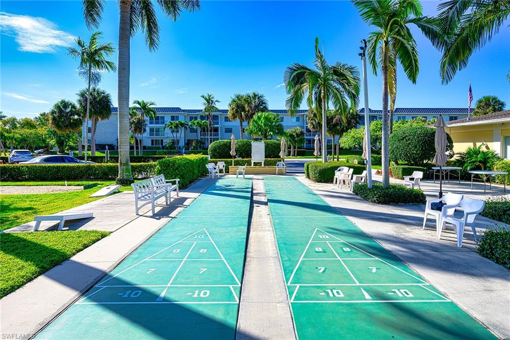 637 12th Avenue South, Unit 637 Naples, FL 34102 - Photo 25 of 35 a view of a swimming pool with a table and chairs