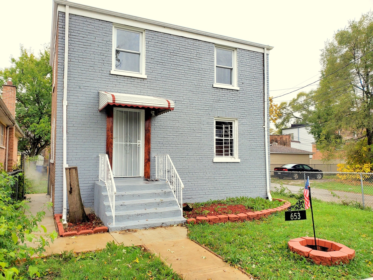 653 East 105th Street Chicago, IL 60628 - Photo 1 of 27 a front view of a house with a yard