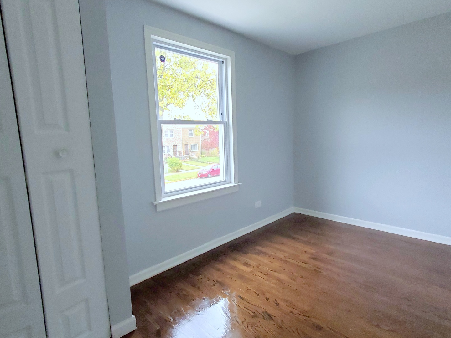 653 East 105th Street Chicago, IL 60628 - Photo 15 of 27 a view of an empty room with wooden floor and a window